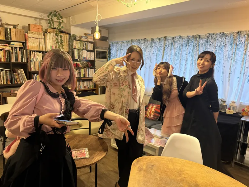 本棚のある会場でポーズをとる出演者たち